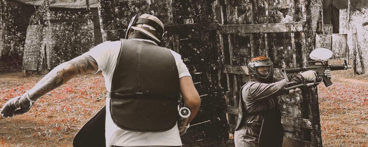 Duas pessoas jogando paintball. 