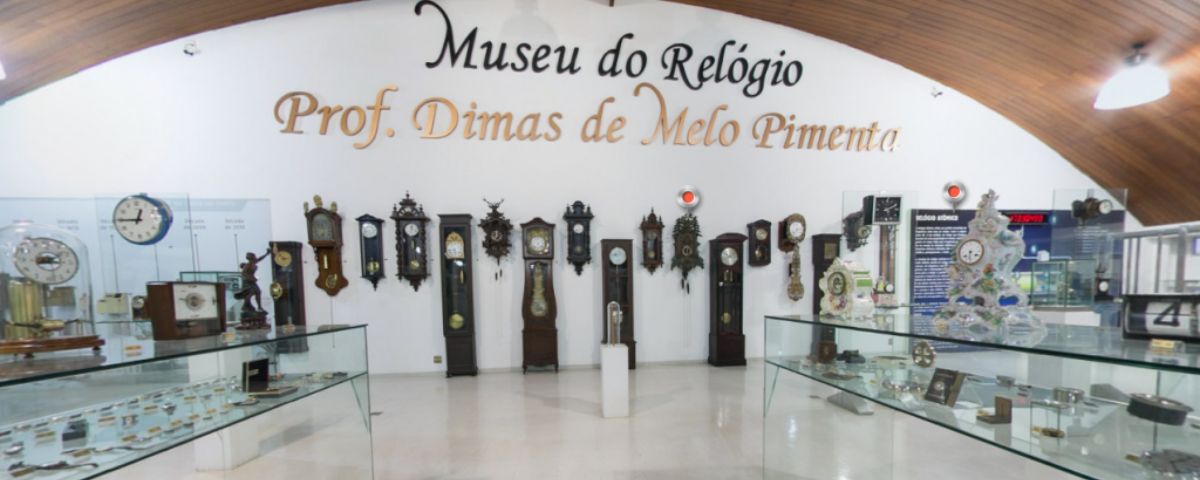 Salão do Museu do Relógio com diversos relógios antigos na parede. 