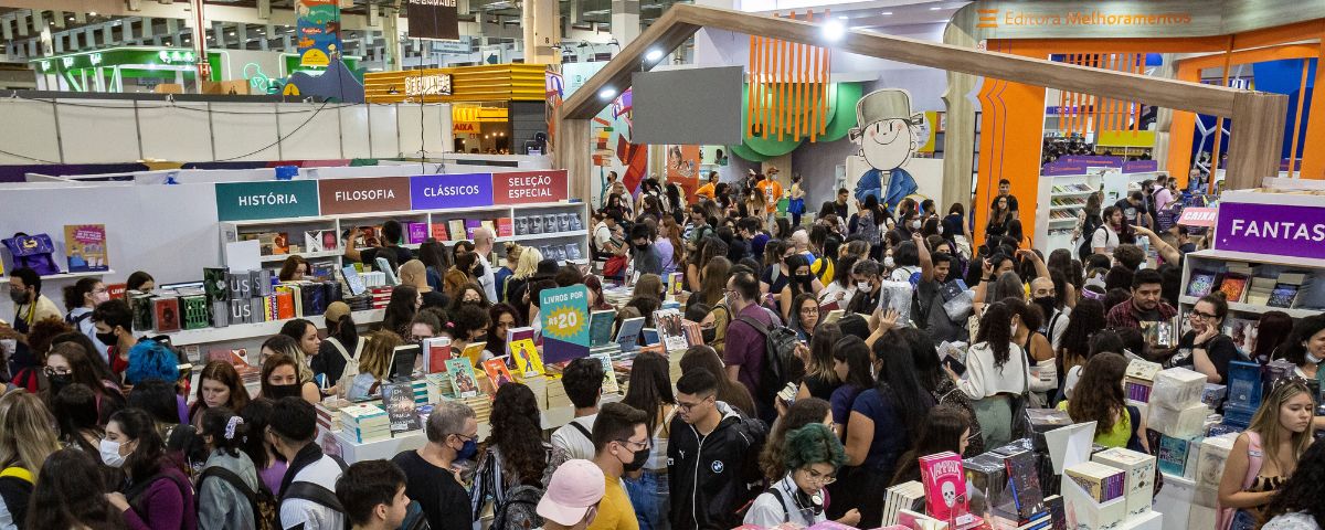 Bienal do Livro em São Paulo, com diversas pessoas olhando os estandes com livros. 