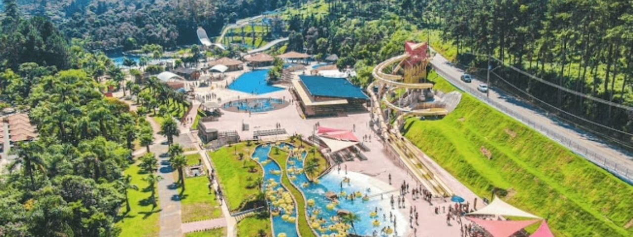 A imagem aérea mostra o complexo do parque em meio a natureza em um dia ensolarado