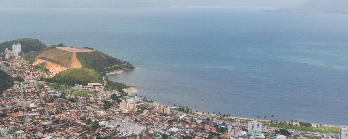 A imagem mostra uma cidade praiana, com orla e mar