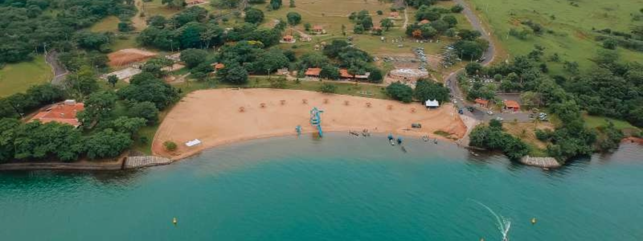 A imagem mostra a orla de uma pequena praia