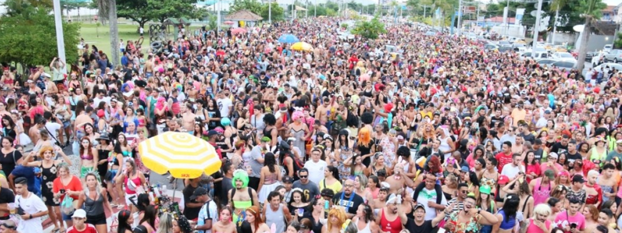 A imagem mostra a multidão reunida na rua no bloco de carnaval 