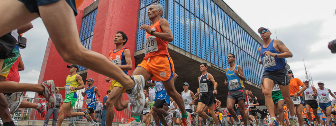 A imagem mostra os corredores na São Silvestre e ao fundo o Masp 