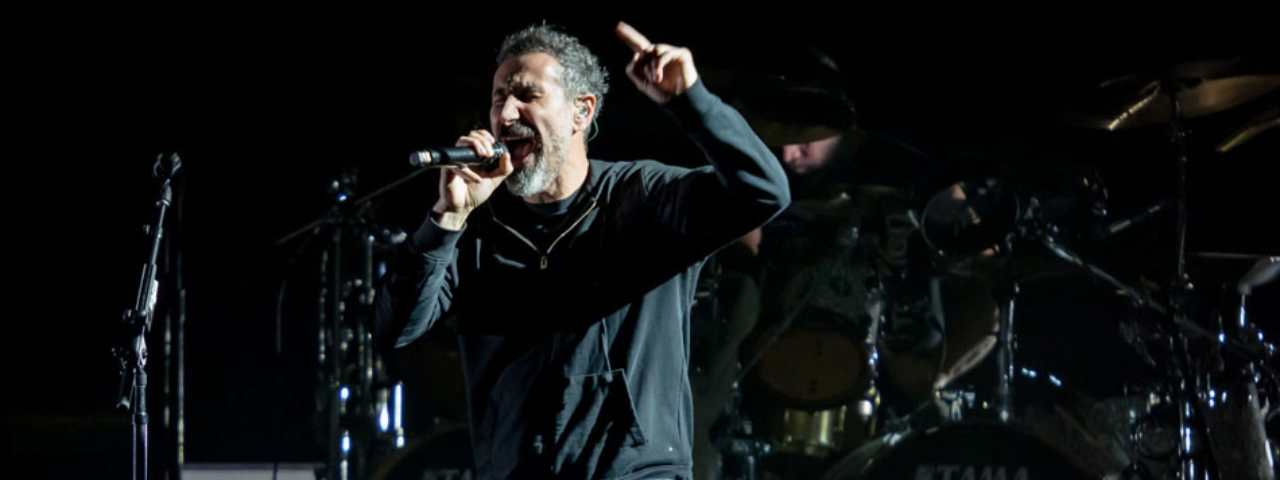 A imagem mostra o vocalista da banda System of a Down contando