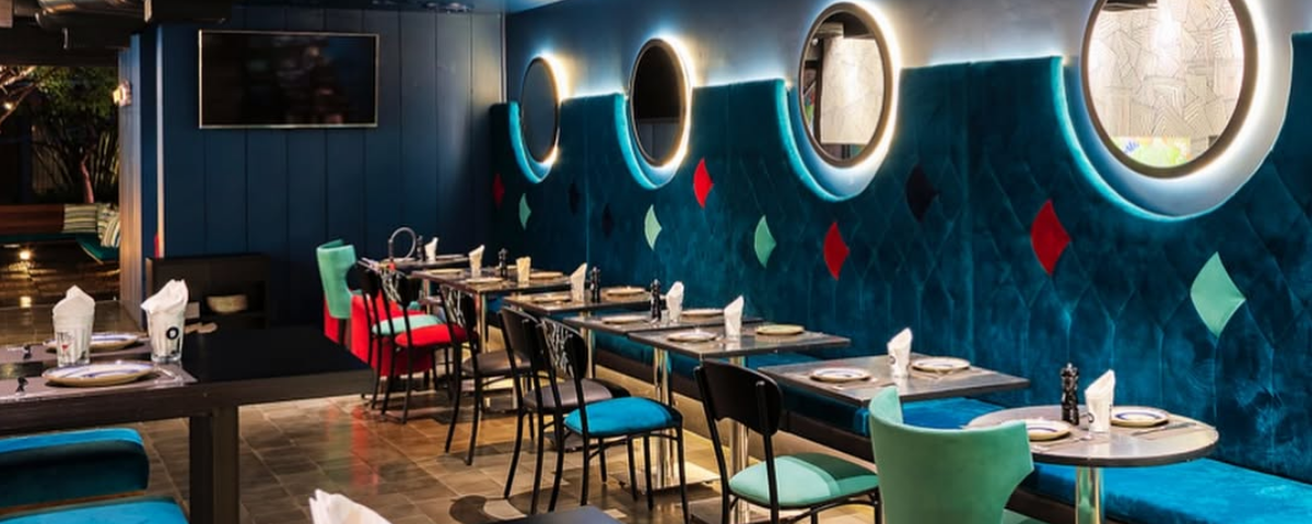 Interior do Caulí Lounge Bar com seu visual vibrante e iluminação colorida, ideal para um sextou com drinks autorais em SP
