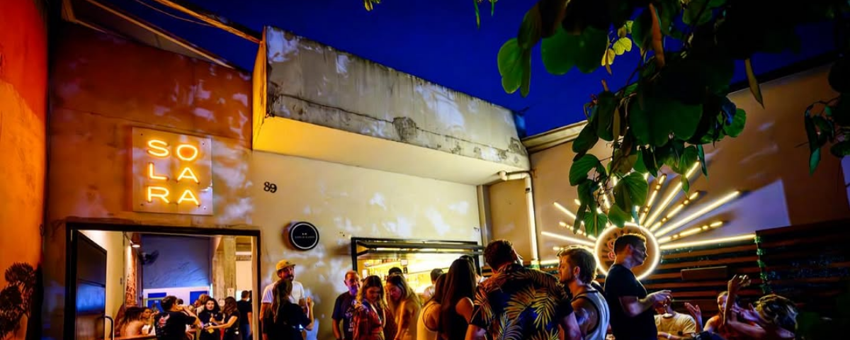 Área externa animada do Solara Bar com pessoas aproveitando a noite, ideal para um sextou com drinks autorais ao ar livre em SP