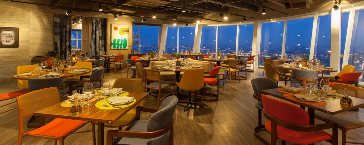 Vista do salão giratório do Lassù Ristorante, um local que combina alta gastronomia italiana com panoramas de 360 graus de São Paulo