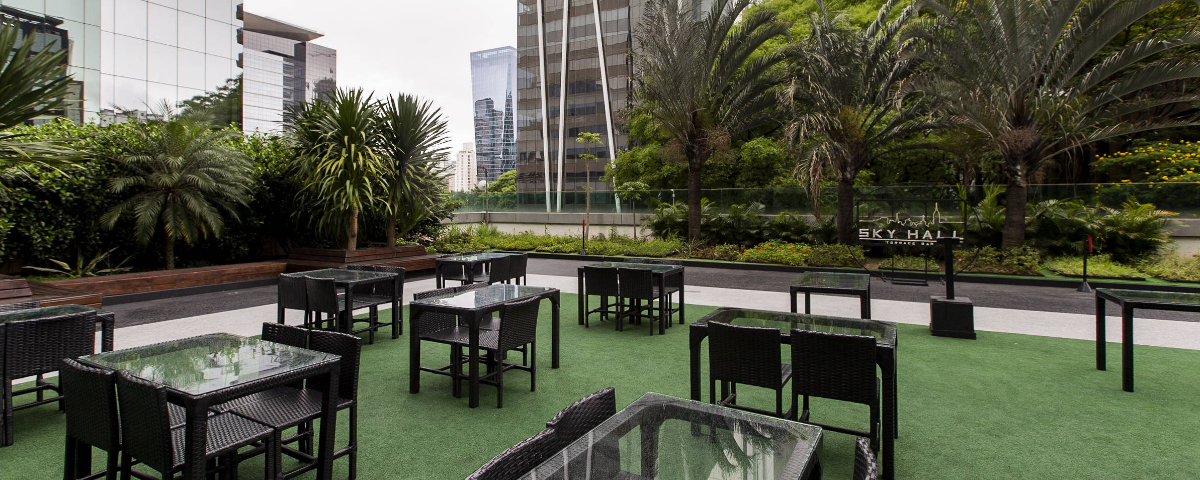 Vista sofisticada do Sky Hall Terrace Bar, mostrando o skyline moderno de São Paulo com um ambiente ideal para drinks e experiências premium