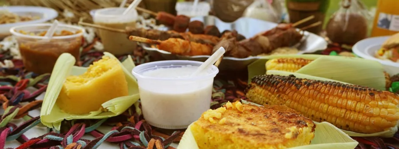 Mesa com comidas típicas de festa julina, como bolo de milho e canjica, um dos eventos temáticos em SP na primeira quinzena de julho