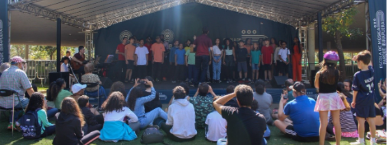 Público sentado no gramado durante o evento Música no Parque, uma opção de lazer cultural em SP na primeira quinzena de julho