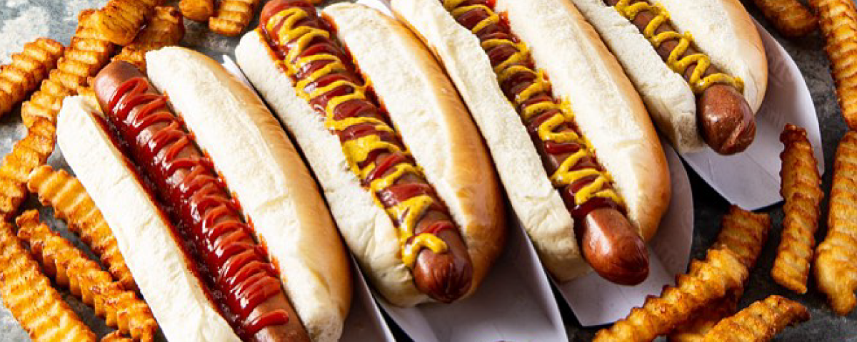 Hot dogs variados rodeados por porções de batatas fritas, uma combinação irresistível e perfeita para compartilhar