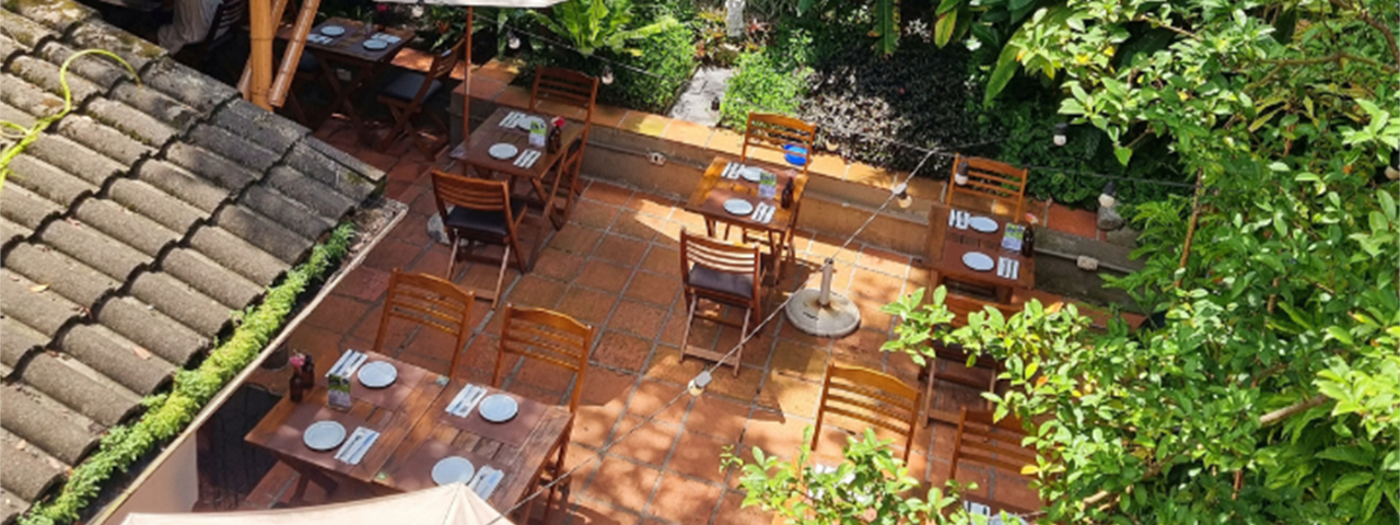 Parte externa do restaurante Casa RAW em São Paulo, com mesas ao ar livre e clima acolhedor