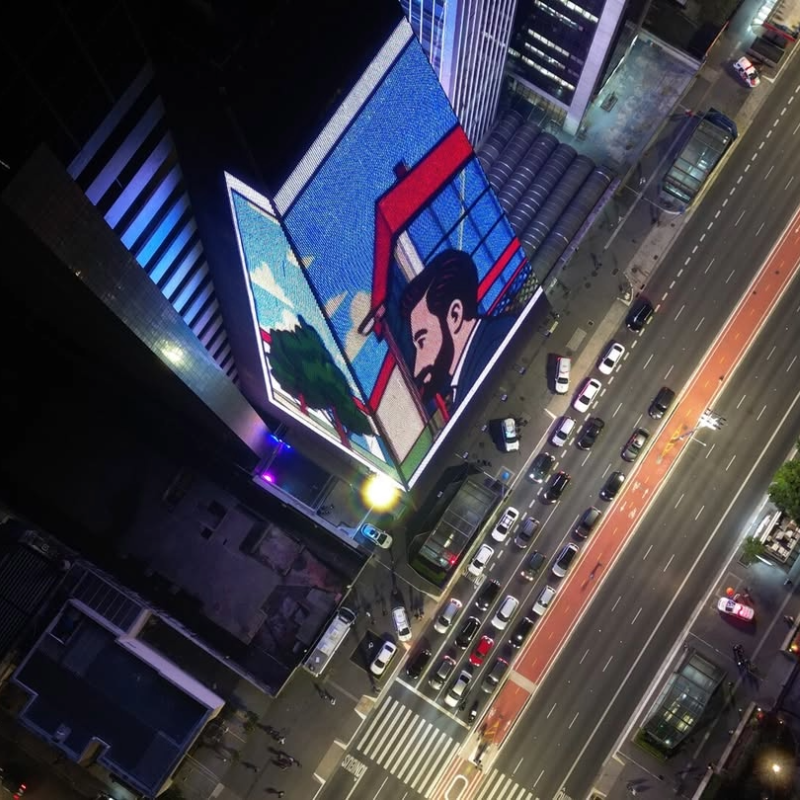 Imagem aérea do prédio da Fiesp com uma projeção artística na fachada de LED, localizado na Avenida Paulista.