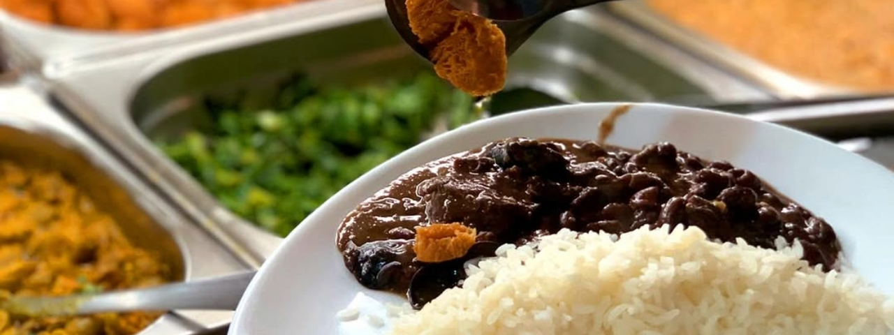 Um prato vegetariano em primeiro plano e ao fundo um buffet repleto de opções vegetarianas em São Paulo