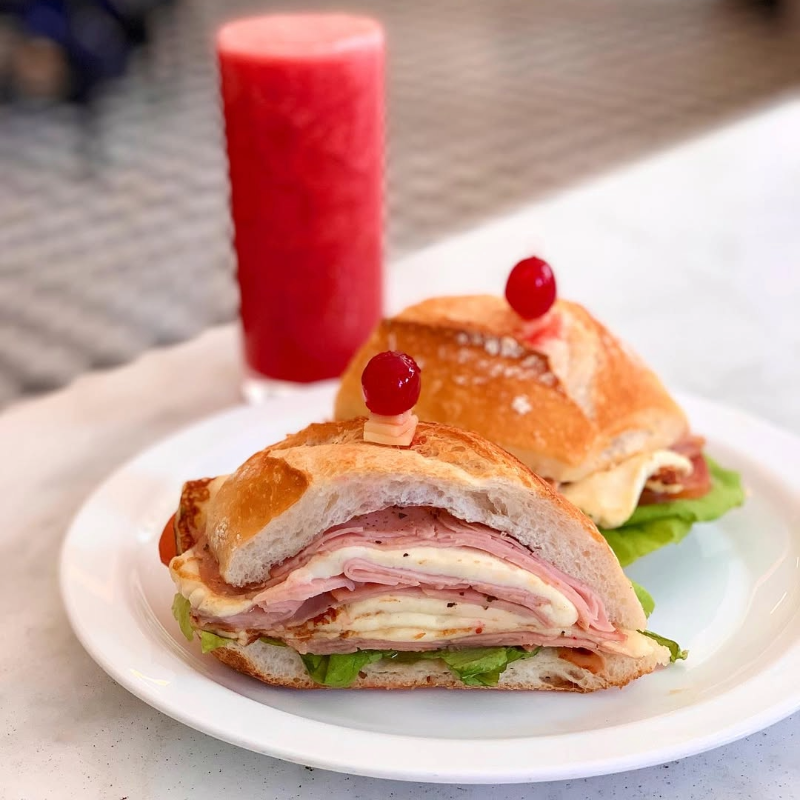 Clássico sanduíche de mortadela acompanhado por um copo de suco natural, uma refeição icônica em São Paulo
