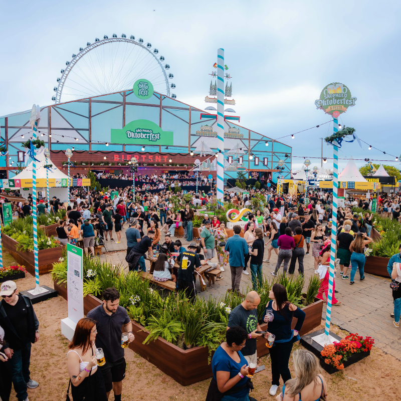 Pessoas animadas curtindo o evento da Oktoberfest em São Paulo, com músicas, trajes típicos e muita diversão