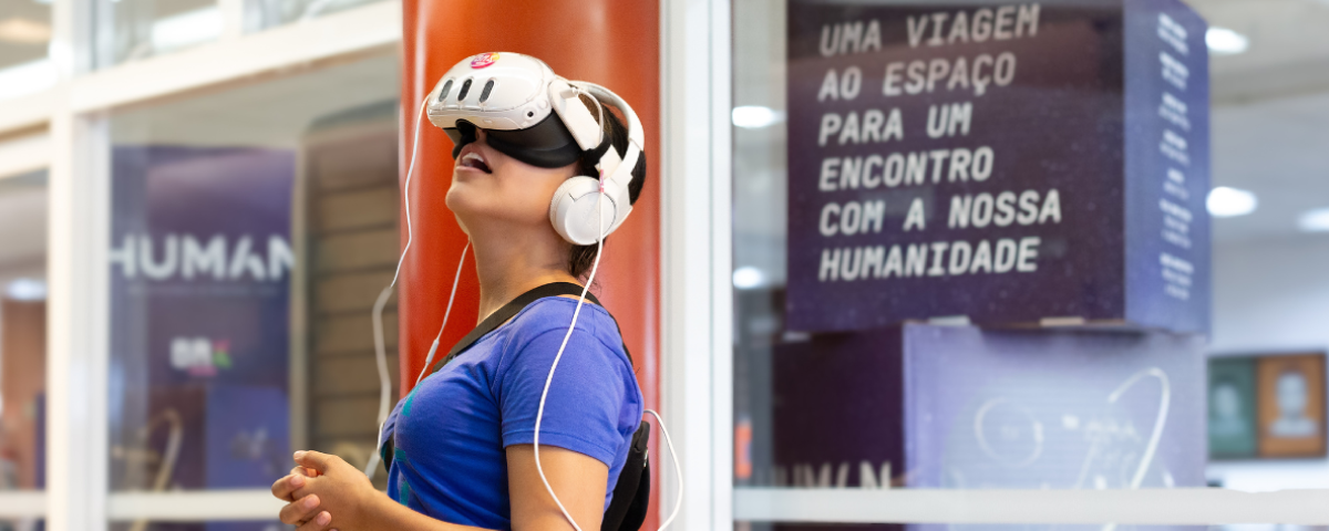 Mulher vestindo um óculos de realidade virtual durante a feira Orgulho Nerd, experimentando tecnologia interativa
