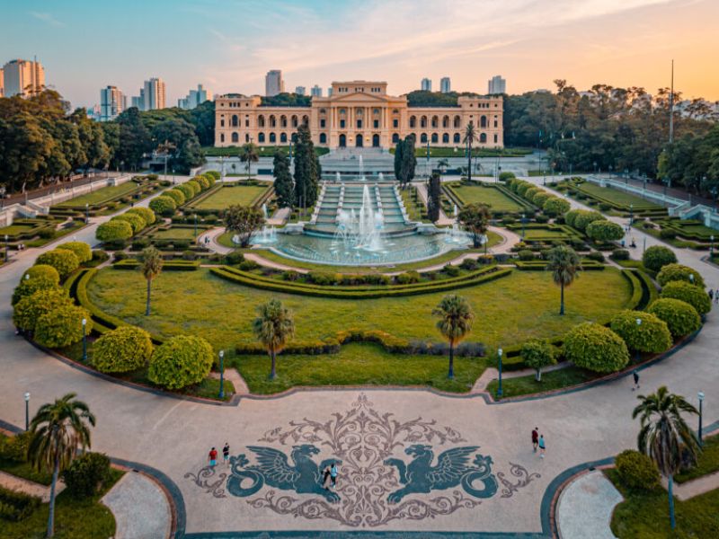 imagem mostra museu do ipiranga com chafariz na frente e jardim ao redor