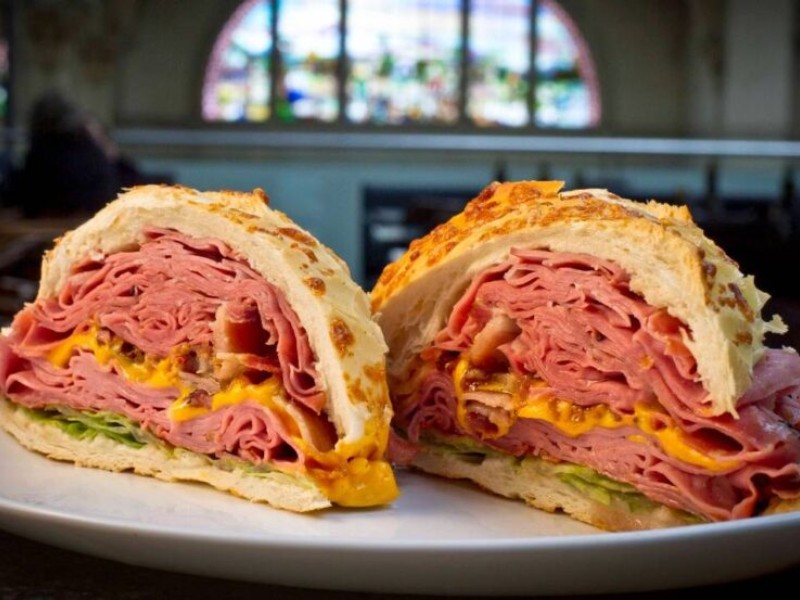 imagem mostra duas metades de um sanduiche de mortadela em um prato