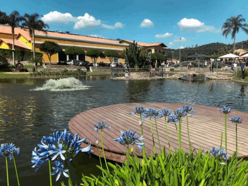 imagem mostra lago com jardim e restaurantes ao redor