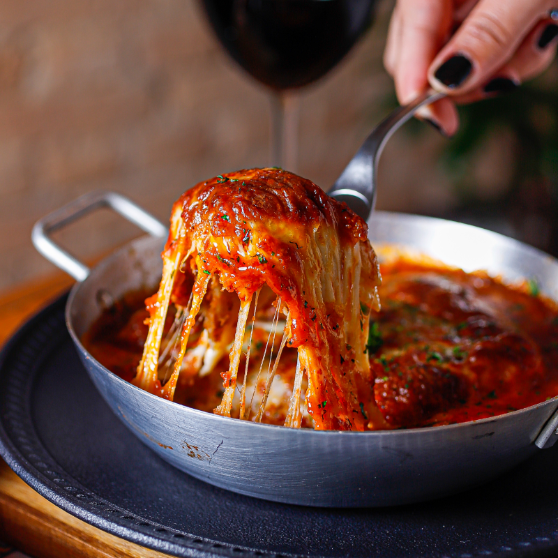 Prato de Parmigiana com molho de tomate, queijo derretido e acompanhamento, disponível no menu do Restaurant Week