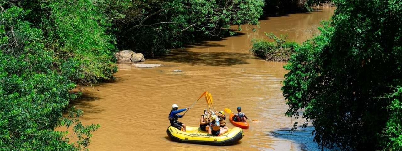 Turistas em um bote praticando rafting no rio de Socorro, vivenciando aventura e contato com a natureza