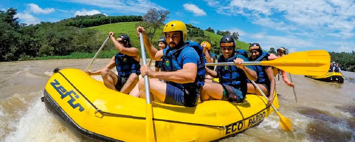 Equipe praticando rafting em forte correnteza, rodeada por paisagens naturais exuberantes