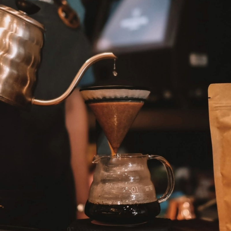 Café sendo coado de forma artesanal, ressaltando técnicas e experiência sensorial em uma cafeteria de São Paulo