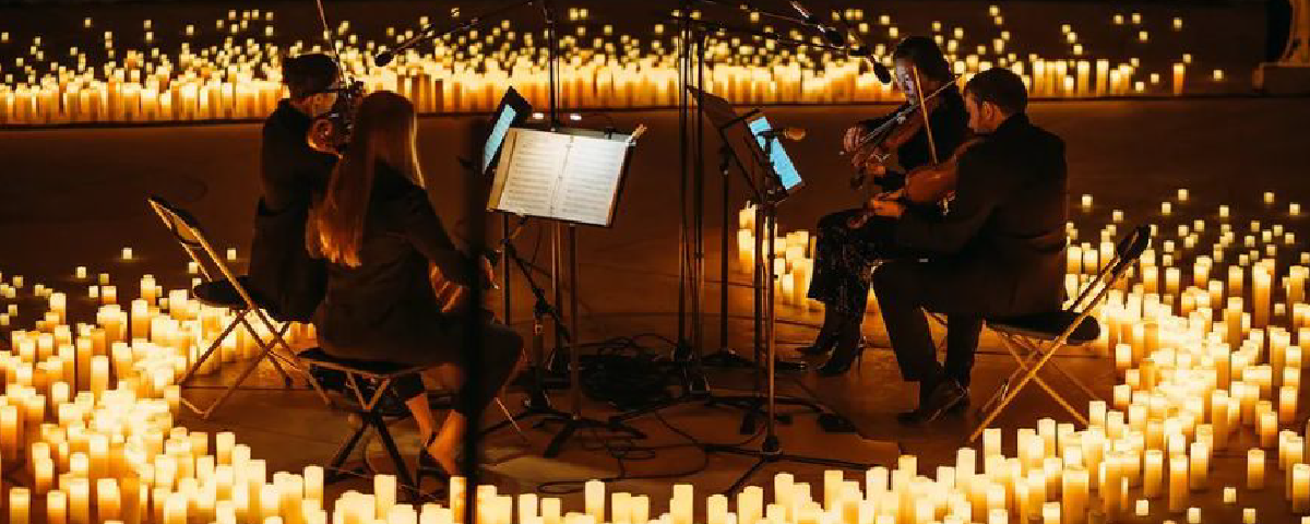Músicos em apresentação intimista durante um evento Candlelight, com iluminação de velas