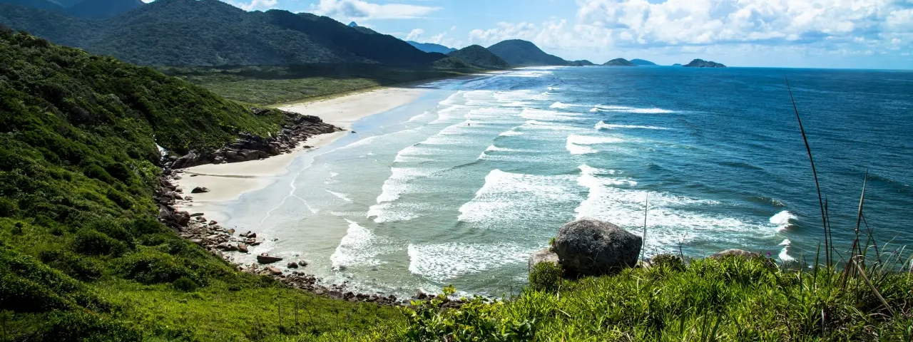 Praia da Laje em Cananeia, com paisagem natural preservada e águas cristalinas. (Foto: Yuri Cruvinel Ribeiro/Wikimedia Commons / Divulgação)