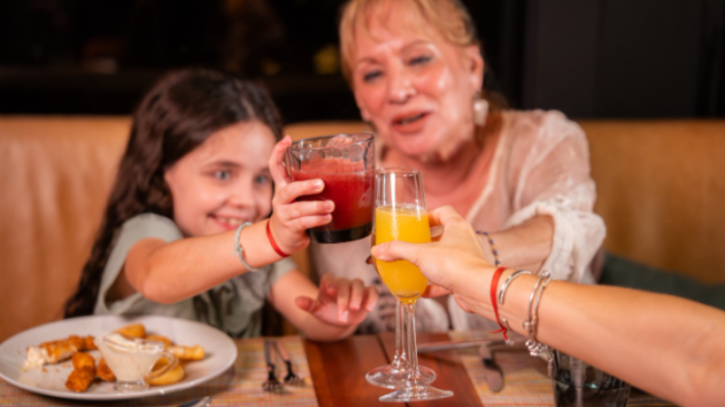 Família brinda durante brunch de Dia das Mães no Canopy by Hilton São Paulo Jardins, com bebidas servidas à mesa em ambiente acolhedor e descontraído.