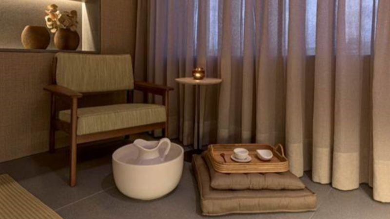 Ambiente do Spa Fasano com poltrona, banheira para escalda-pés, bandeja de chá e iluminação aconchegante voltada ao relaxamento.