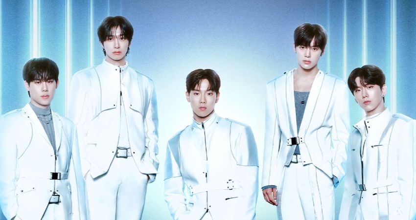 Imagem promocional do grupo de K-pop Monsta X mostra cinco integrantes usando figurinos brancos em cenário futurista iluminado por luzes em tons de azul.