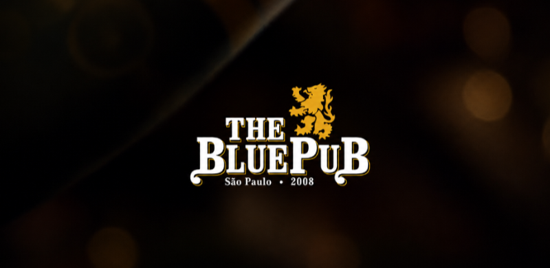Logotipo do The Blue Pub sobre fundo escuro desfocado em tons de preto e dourado. A marca apresenta o nome "The Blue Pub" em letras brancas com detalhes dourados, acompanhado de um leão estilizado na parte superior e da inscrição "São Paulo • 2008".