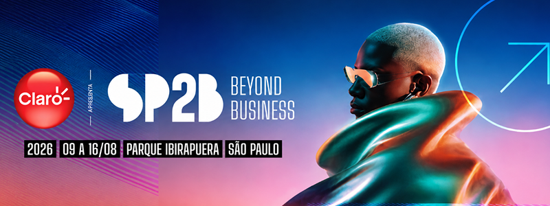 Arte promocional do São Paulo Beyond Business (SP2B) 2026. O fundo combina um degradê em tons de azul, roxo e rosa com elementos gráficos de estética futurista. À esquerda, aparecem os logotipos da Claro e do SP2B Beyond Business, acompanhados das informações 2026, 9 a 16 de agosto, Parque Ibirapuera e São Paulo. À direita, uma pessoa de perfil, com cabelo platinado curto e óculos espelhados, veste uma peça de aparência metálica em tons iridescentes de azul, verde e cobre. No canto superior direito, um ícone de seta ascendente dentro de um círculo reforça a identidade visual do evento. A composição utiliza iluminação em neon e transmite uma atmosfera de inovação, tecnologia e negócios.