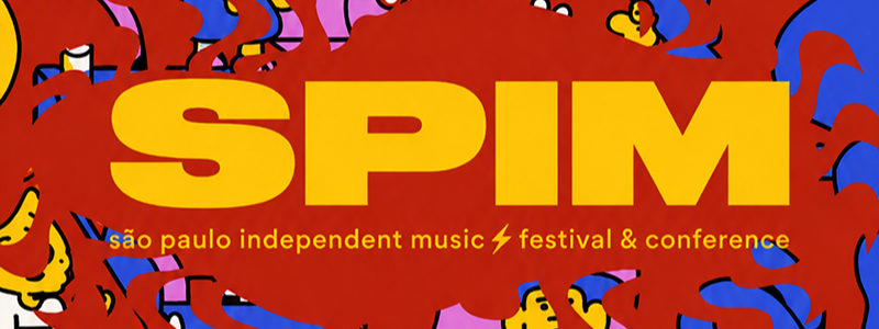 Ilustração em estilo cartaz, com traços grossos e cores vibrantes como vermelho, amarelo, azul, rosa e roxo. A cena representa um ambiente lúdico inspirado em um festival de música, repleto de personagens caricatos distribuídos por diferentes níveis, escadas, plataformas e salas. Há um DJ em uma cabine, caixas de som, mesas, plantas, um aquário com um peixe azul e diversos elementos decorativos espalhados pela composição. No centro, uma grande forma vermelha destaca o título “SPIM” em letras amarelas, seguido da frase “São Paulo Independent Music Festival & Conference”. A ilustração transmite uma atmosfera criativa, divertida e dinâmica, com muitos detalhes que remetem à música, à arte e ao convívio social.